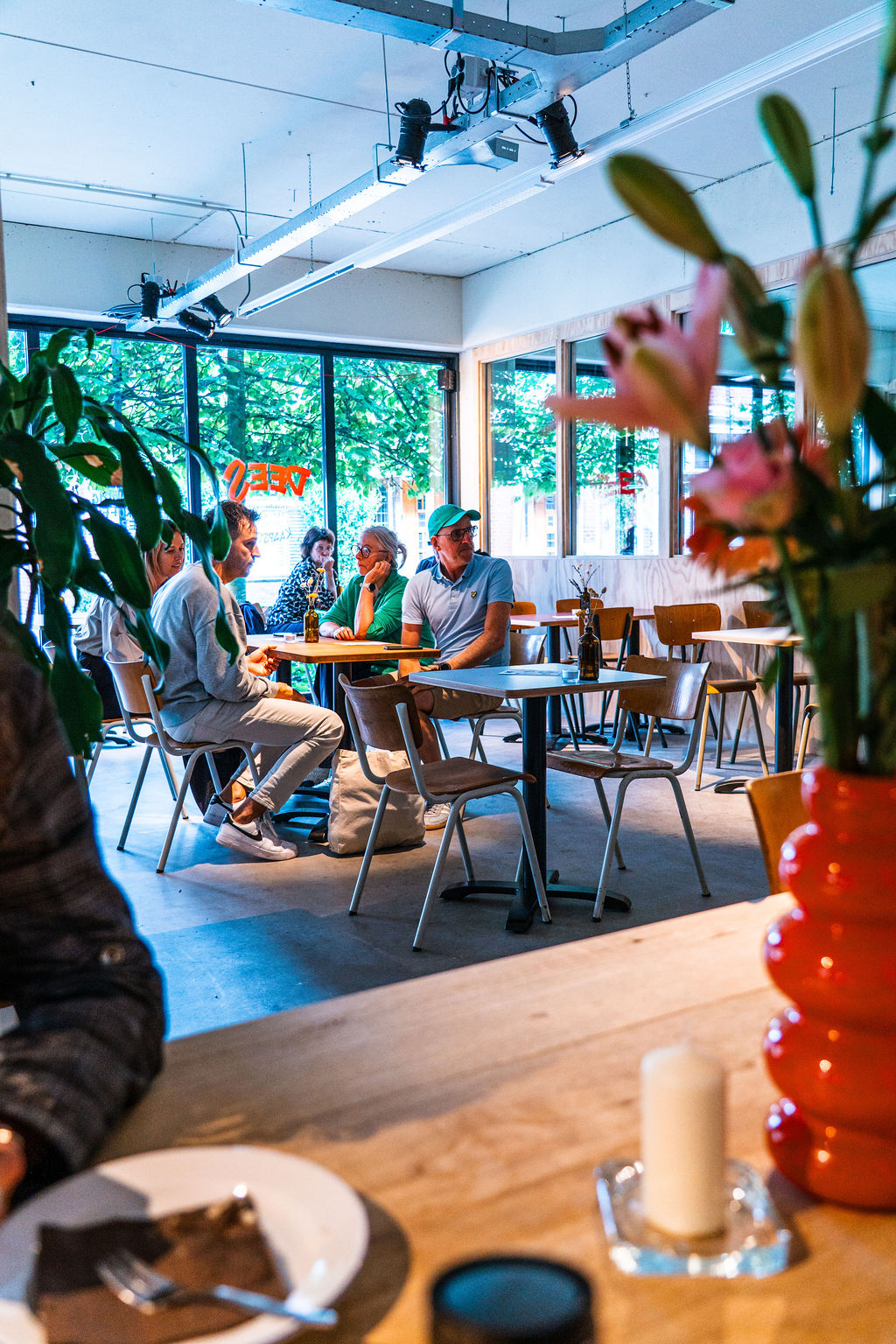 Gasten aan tafel in het interieur van Dees.